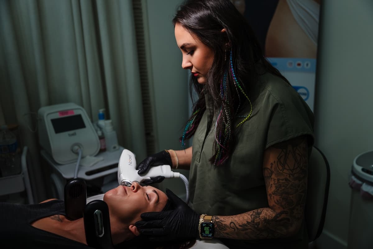 Wichita Laser Clinic provider treating a reclining client's face with the Tixel handpiece